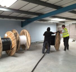 Picture of 2 people rolling out wires
